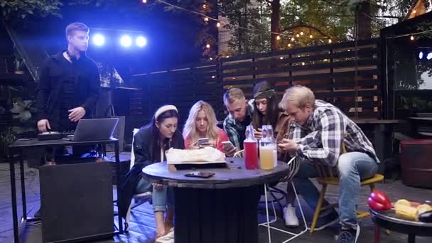 Concentraated young people sitting at the table and looking everyone into their phone — Stock Video