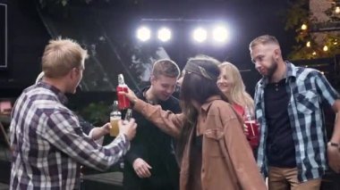 Mutlu neşeli 30s insanlar clinking şişe ve dj tarafından oynanan müzik dans ile toplantı kutluyor