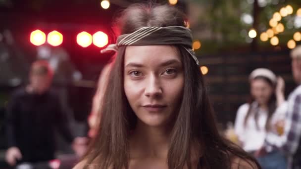 Pretty young woman with bandanna on her head posing on camera in the evening — Stock Video