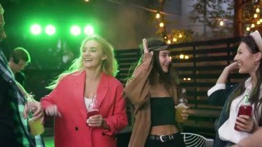 Gülümseyen dans iyi arkadaşlar yakışıklı arkadaşı yaklaşan şirket onların müzik partisi için ızgara sebze pişirme