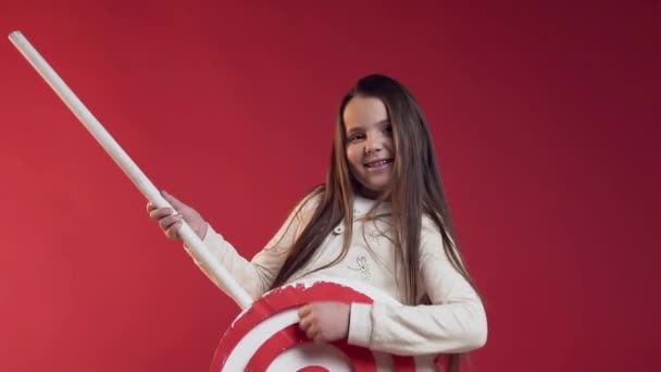 Funny sprudlande tonåring leker med plast Lollipop som en gitarr på den röda bakgrunden — Stockvideo