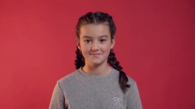 Kırmızı arka plan üzerinde altın konfeti ile eğlenmek örgüleri ile sevimli neşeli genç kız Çekici portre