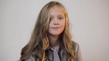 Beyaz duvar arka planda kamera poz sarı saçlı sevimli gülümseyen genç kız Çekici portre