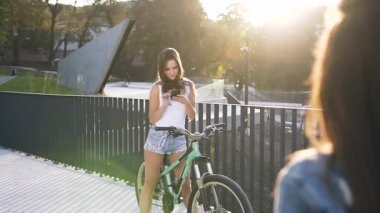 İki güzel genç kadının açık havada yaptıkları toplantı sırasında birbirlerine beş lik yüksek bir şekilde verdikleri yavaş çekim