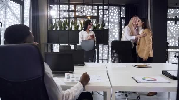 Aantrekkelijke drie zakenvrouwen begroeten elkaar met knuffels voor het begin van hun werk in de vergaderzaal — Stockvideo