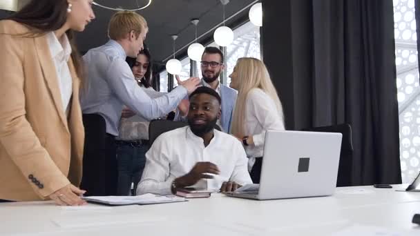 Aangenaam jong multiraciaal werkteam dat elkaar bedankt voor vruchtbare samenwerking in het kader van hun computerproject in de kantoorruimte — Stockvideo