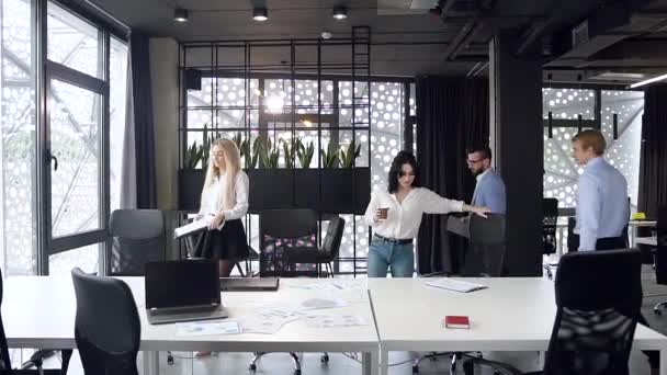 Медленное движение смешанных гонок приятные яркие деловые коллеги, работающие в конференц-зале с различными бумажными отчетами и настольным ноутбуком — стоковое видео