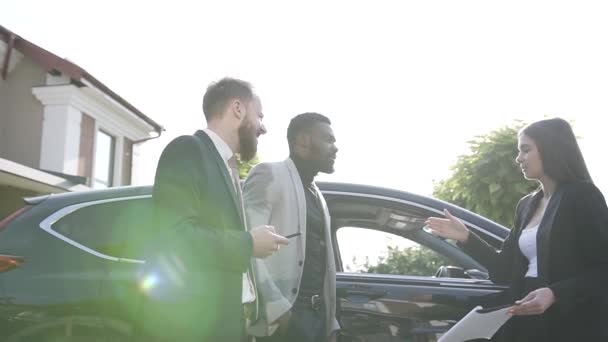 Tres jóvenes empresarios en trajes formales discuten para negociar, se dan la mano mientras se saludan antes de una reunión de negocios o una cumbre — Vídeos de Stock