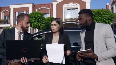 Kafkasyalı iş kadını ve işadamı başarılı Afrikalı adam, iş belgeleri, dizüstü bilgisayar ve tablet bilgisayar kullanarak önemli iş akışlarını tartışıyor. Portre