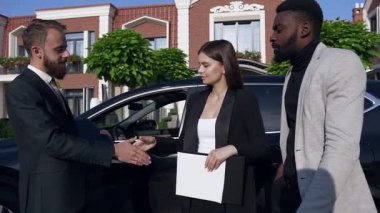 Afrika kökenli Amerikalı ve beyaz bir adamla genç bir iş kadını başarılı takım çalışması için el sıkışıyor.