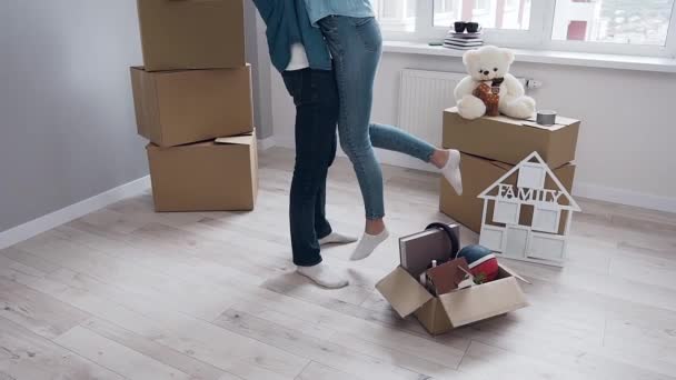 Movimento lento de esplêndido jovem casal que celebrando seu primeiro dia em novo apartamento entre diferentes caixas — Vídeo de Stock