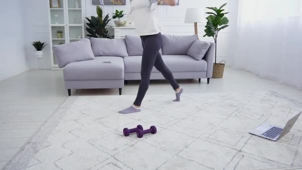 Movimento lento de feliz esplêndida morena esportiva de 25 anos que segurando em seu ombro bonito menina engraçada e agachando-se com ela em casa — Vídeo de Stock