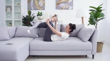 Evde birlikte eğlenen mutlu anne ve küçük kızın portresi.