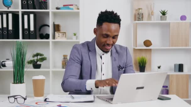 Good-looking successful professional smiling black-skinned man sitting in front of the laptop and is glad from the good news on screen ,close up,4k — Stock Video