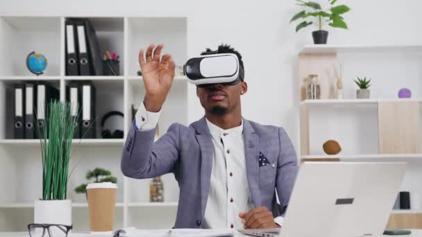 Retrato de agradable experimentado considerado joven hombre de negocios de piel negra en ropa elegante que trabaja en la pantalla virtual utilizando gafas 3d especiales, 4k — Vídeos de Stock