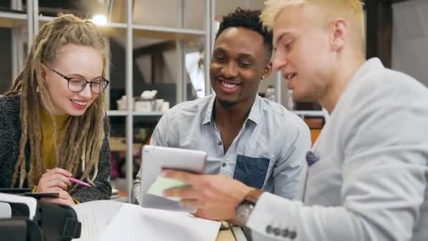 Equipo de trabajo experimentado multirracial contento agradable que compara los datos del i-pad y del documento financiero durante el trabajo conjunto en la oficina contemporánea — Vídeos de Stock