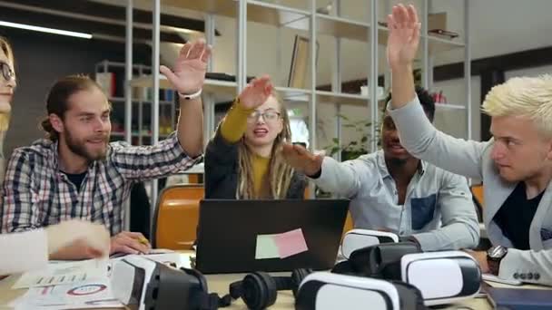 Portret van uitbundige sympathieke jonge internationale collega 's die elkaar de hand leggen voordat ze met succes aan het werk gaan in een hedendaags kantoor — Stockvideo