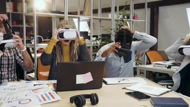 Close-up van aantrekkelijke tevreden creatieve internationale workteam dat werkt in virtual reality headset in hedendaags kantoor — Stockvideo