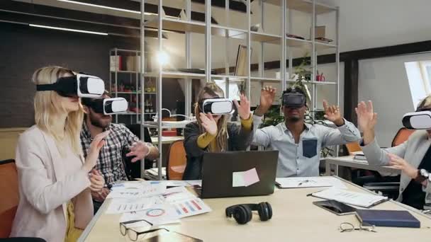 마음에 드는 다양 한 창의적 인 그룹의 프론트 뷰 가상 화면에서 현대 사무실에 있는 특수 3d 안경을 사용하여 손을 움직이는 동료 — 비디오