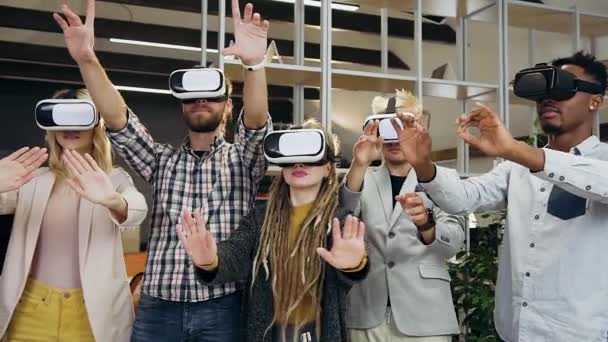 Vooraanzicht van zelfverzekerde goed uitziende jonge gemengde ras kantoor vrienden die werken op interactieve scherm in virtual reality headset — Stockvideo