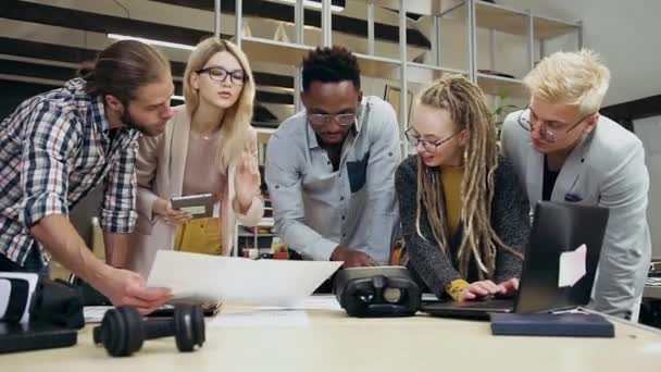 Vooraanzicht van sympathieke tevreden creatieve ervaren multiraciale team dat samenwerkt in het kader van een gezamenlijk project in prachtige kantoorruimte — Stockvideo