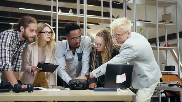 Aantrekkelijk gemotiveerd zelfverzekerd creatief multiraciaal team dat samenwerkt in hedendaags kantoor met financiële gegevens en informatie van de computer — Stockvideo