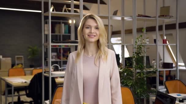 Atraktivní radostná profesionální mladá podnikatelka s kroužkem v nose pózující na kameře v současné kancelářské místnosti se zkříženými pažemi — Stock video