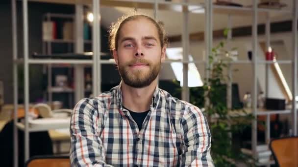 Beau professionnel satisfait confiant jeune travailleur masculin avec barbe regardant la caméra avec les bras croisés dans la salle de travail moderne — Video