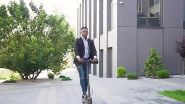 İyi görünümlü Afro-Amerikalı, e-scooterına binip açık havada motosiklet süren açık renk saçlı erkek arkadaşına beşlik çakıyor.