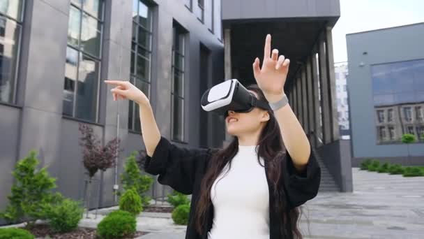Vrij lachend zelfverzekerde jonge aziatische vrouw in virtual reality headset werken op denkbeeldig scherm buiten — Stockvideo