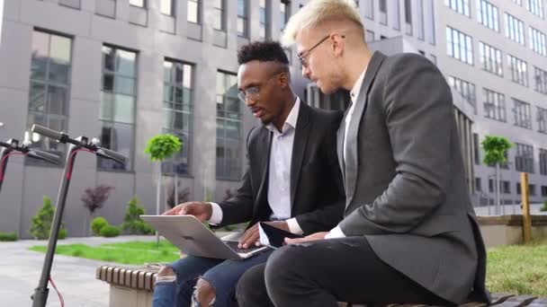 Provável concentrado jovem multirracial escritório trabalhadores trabalhando perto de escritório edifício e saudação com alta cinco seu asiático feminino colega — Vídeo de Stock