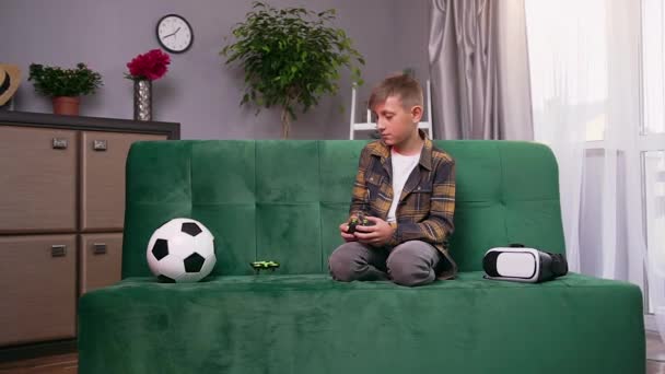 Bonito menino moderno de 10 anos aprendendo a lançar um drone em casa, câmera lenta — Vídeo de Stock