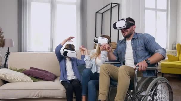 在家里用虚拟现实耳机刻画漂亮而又兴奋的笑容满面的现代家庭，享受着未来的娱乐 — 图库视频影像