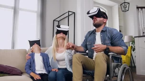 Goed uitziende gelukkig tevreden moderne familie genieten van futuristische entertainment met behulp van speciale 3d bril thuis — Stockvideo