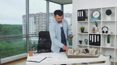 Yeni binaların ahşap inşaatında çalışan ve ölçümleri tasarım ofisindeki i-pad 'e yazan çekici, akıllı, konsantre, genç, sakallı bir mimar.