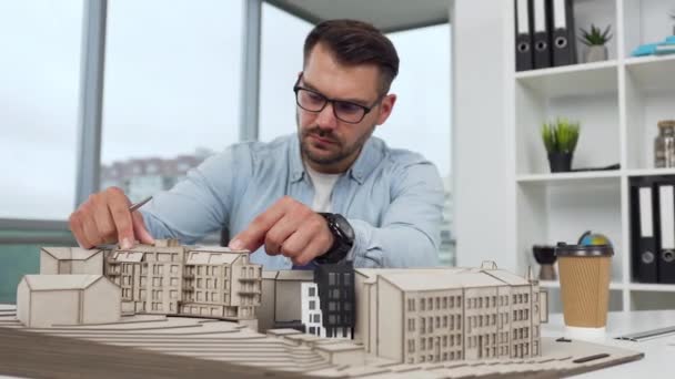 Handsome experienced hardworking 35-aged bearded designer brainstorming the project of new buildings or shopping center in modern architectural bureau, 4k — стоковое видео