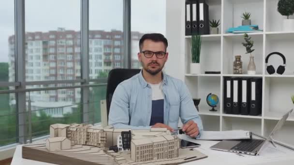 Přední pohled pohledného sebevědomého zkušeného dospělého vousatého architekta v brýlích pózujících na kameru v dobře vybavené designové kanceláři, 4k — Stock video