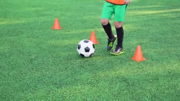 Menino adolescente desconhecido em sportswear jogar futebol no dia de treinamento no campo de futebol com sinais laranja especiais, 4k — Vídeo de Stock