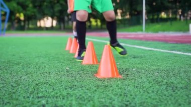 Futbol oyuncularının ayaklarına dikkat edin. Spor yaparken sahada koşmak dayanıklılık sağlar. Futbol sahasında antrenman yaparken.