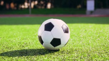 Stadyumdaki maçta yakın koşan ve futbol topunu tekmeleyen futbolcunun ön görüntüsü.