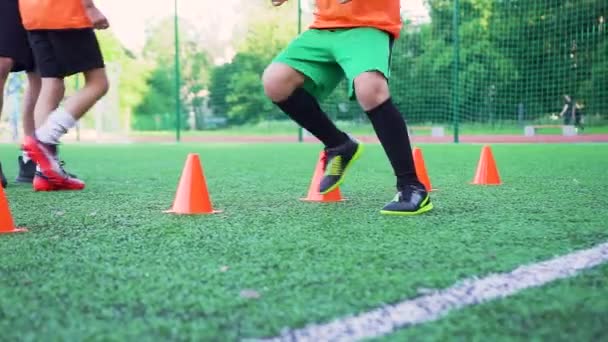 Propósito adolescente rápido en uniforme de fútbol realizar ejercicios rápidos durante el día de entrenamiento en el campo de deporte al aire libre con cobertura especial — Vídeos de Stock