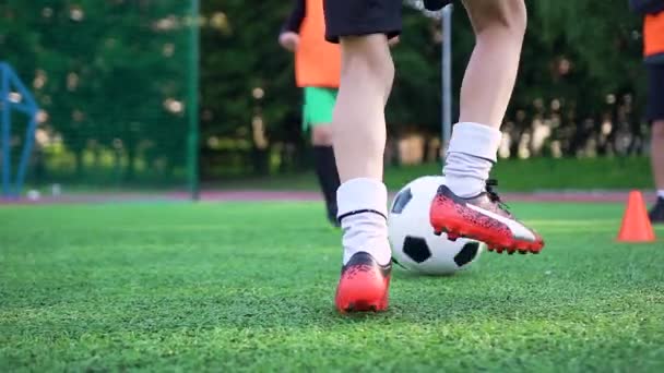Vista próxima de pés de boyss que passando bola um para o outro no dia de futebol de treinamento no campo de esporte ao ar livre — Vídeo de Stock