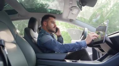 Hoş, sakallı, şık giyimli genç adam kendi arabasının gidonunda gezici sohbetinin keyfini çıkarıyor ve navigatör ve yan görüş kullanıyor.