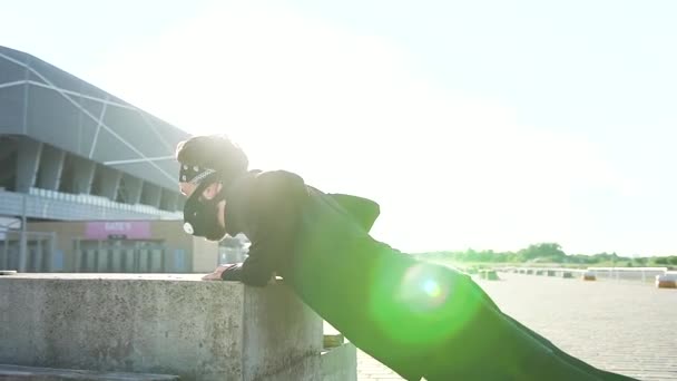 검은 운동복을 입고 마스크를 쓴 매력적 인 자신감 있는 남자의 측면 전망 현대 경기장에서 콘크리트 지원에 대 한 푸쉬 업 — 비디오