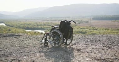 Tekerlekli sandalyeye yakın, sırt çantalı. Tepede duran harika arka planda duran.