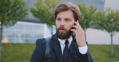 Sırt çantalı yakışıklı, kendine güvenen, sakallı ofis müdürünün ön görüntüsü.