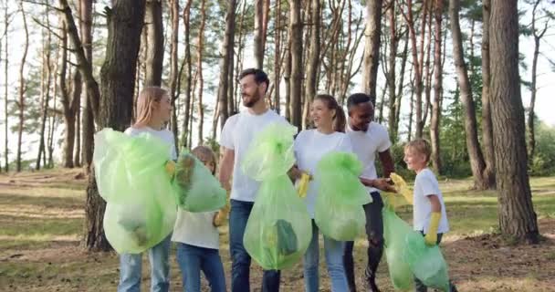 Närbild av sympatisk glad leende multiracial medlemmar av skydd natur gemenskap ha kul tillsammans efter rengöring av parken från utspridda skräp — Stockvideo