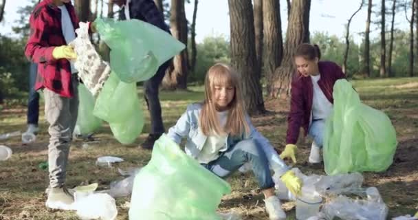 Primer plano de los niños y adultos multirraciales-miembros de la caridad amantes de la naturaleza que limpian el territorio del parque de la basura — Vídeos de Stock