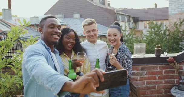 Concepto de amistad donde atractivo en los espíritus jóvenes amigos de raza mixta haciendo selfie durante la reunión en casa de somebodys en la terraza en verano — Vídeos de Stock