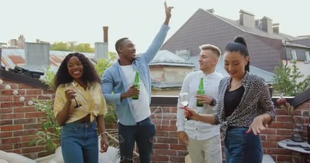 Concept d'amitié où de beaux jeunes multiethniques joyeux et élégants faisant la fête d'été sur le balcon avec de la bière et du vin sous des danses disco — Video